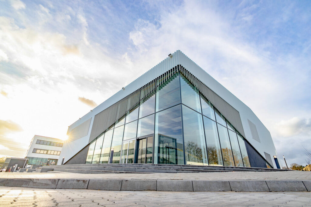 Sunrise behind a modern building made of glass and concrete