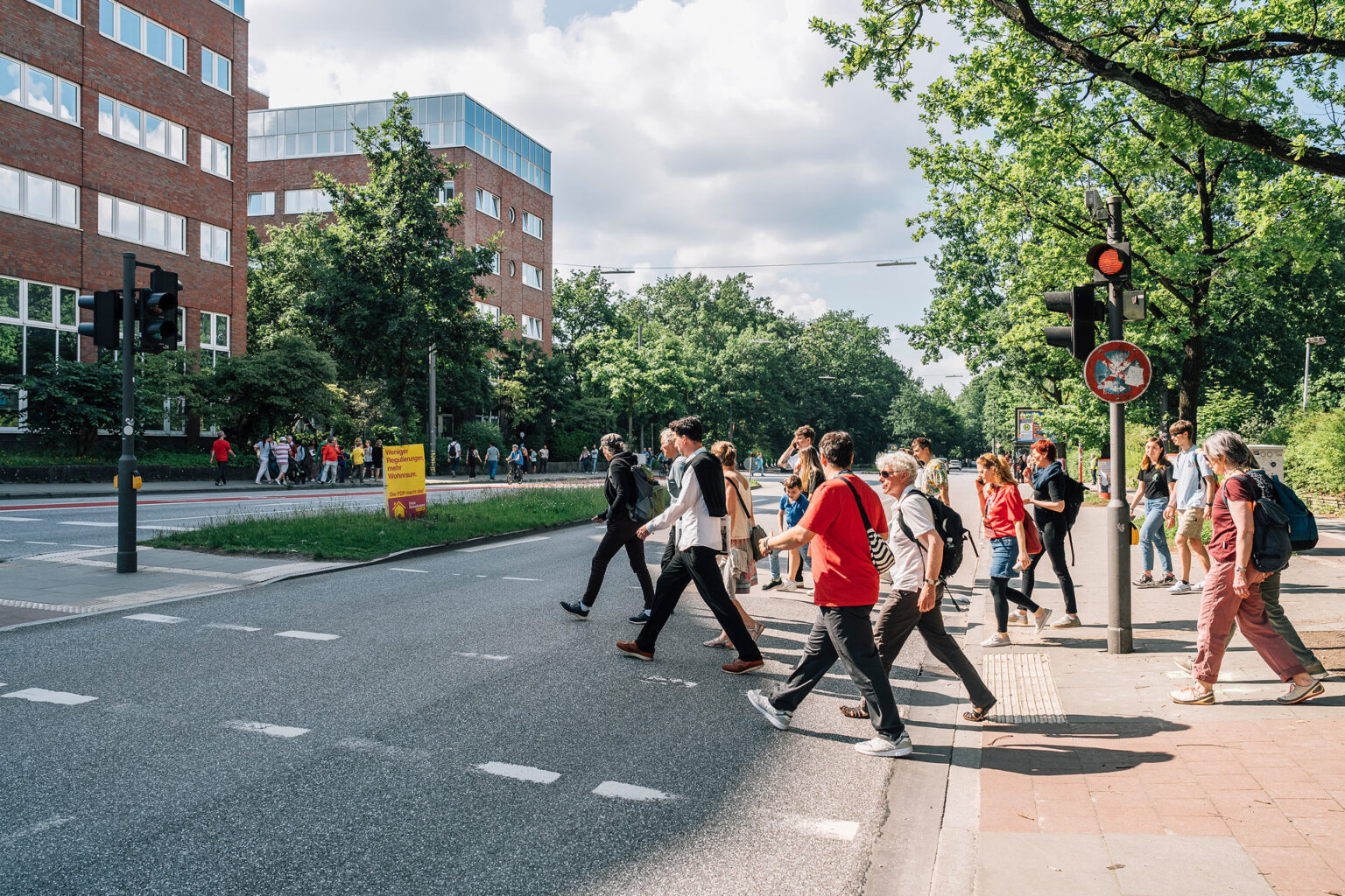 A group of people cross a road together