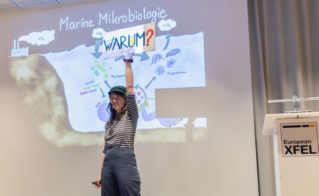 Eine junge Frau präsentiert ihre Forschunge mit kreativen Mitteln.