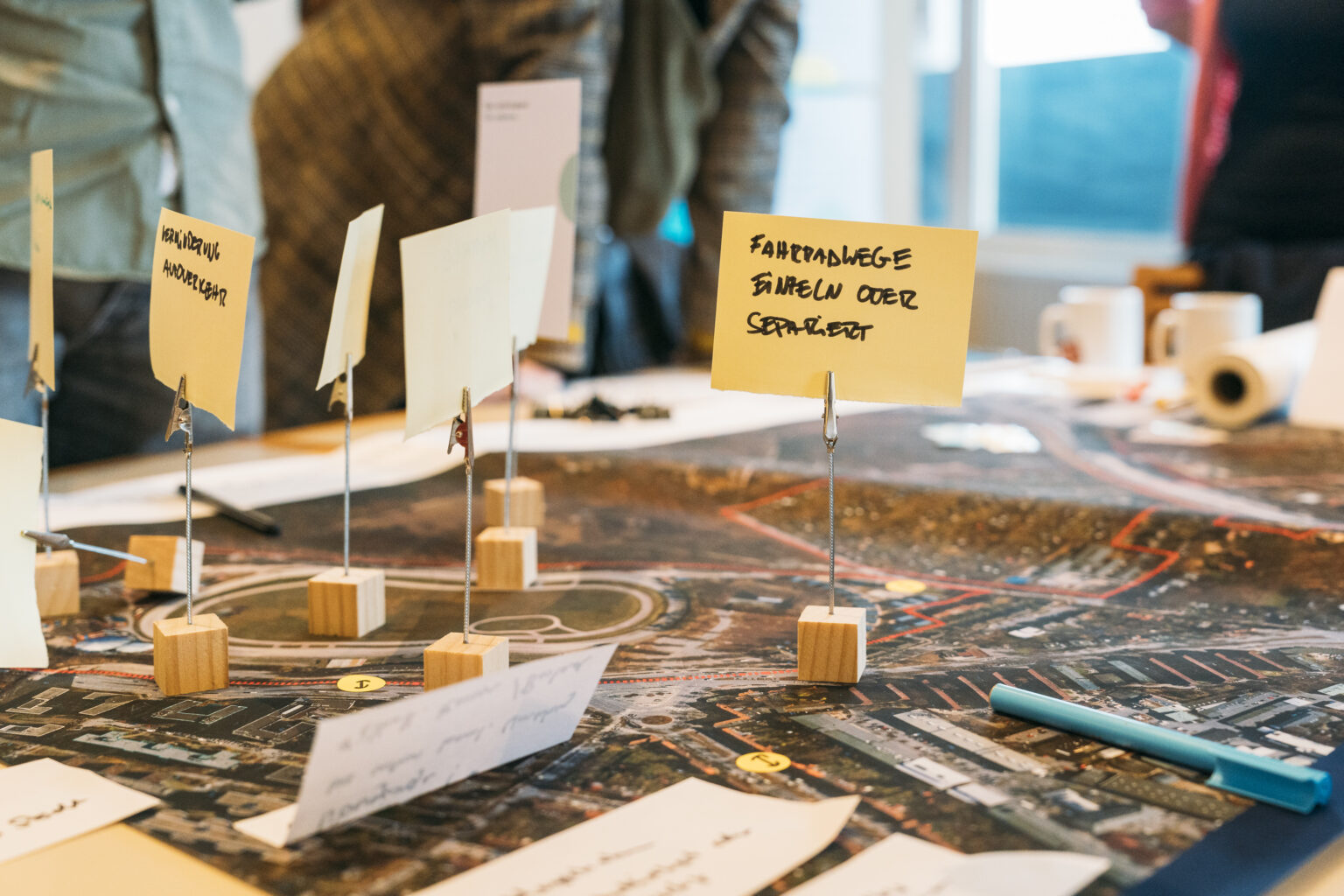 A table with paper and sticky notes that is used for creative ideas and notes.